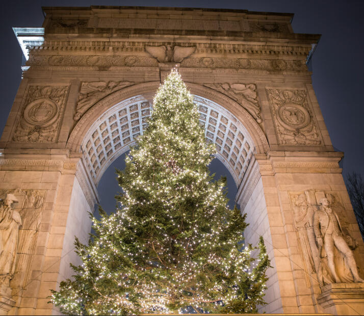 The Washington Square Park Christmas tree lit up underneath the historic Greenwich Village arch.